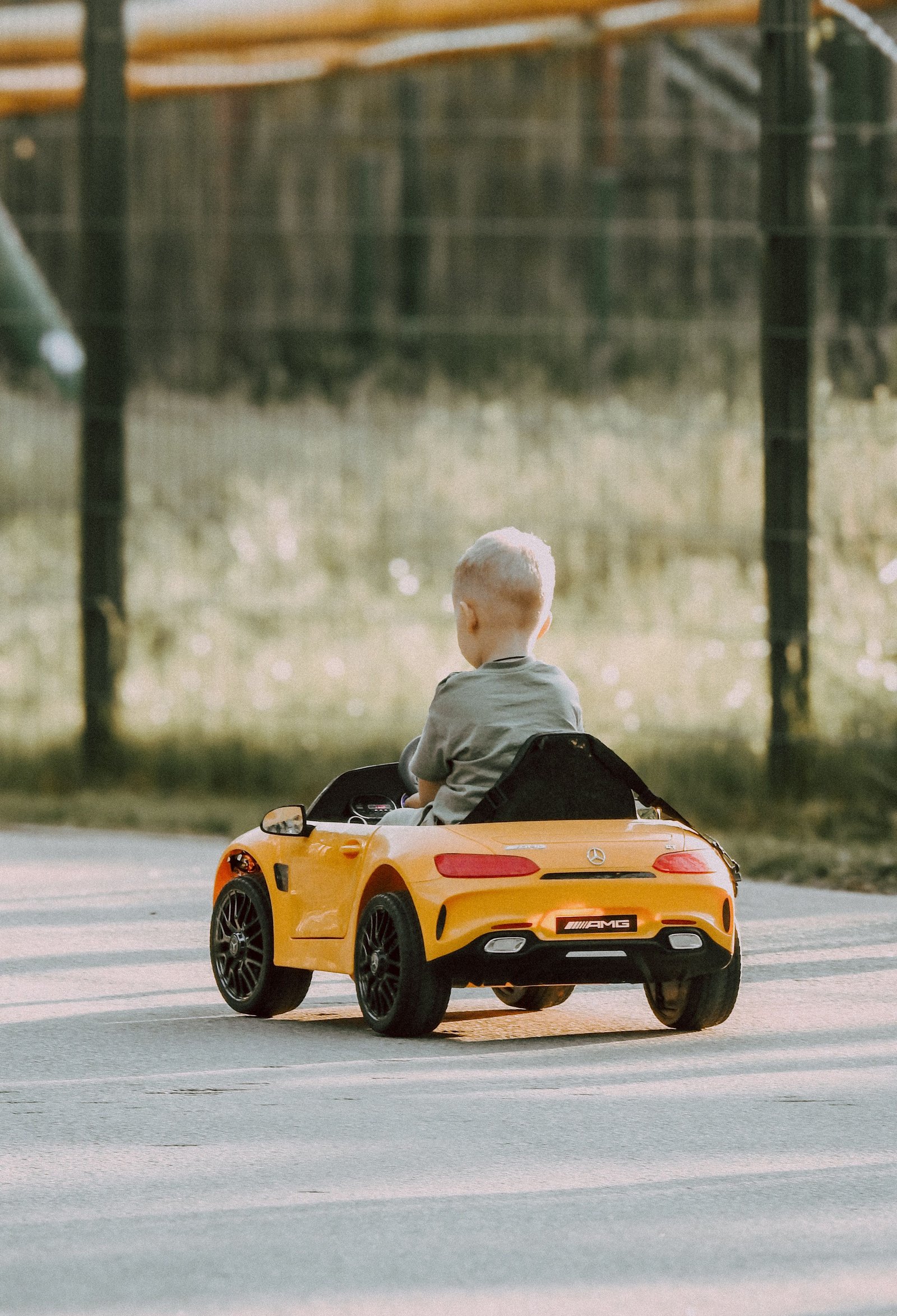 Jeune enfant au volant d'une petite voiture jaune