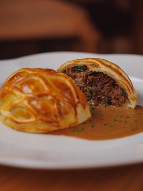 Pie britannique dorée servie dans une assiette