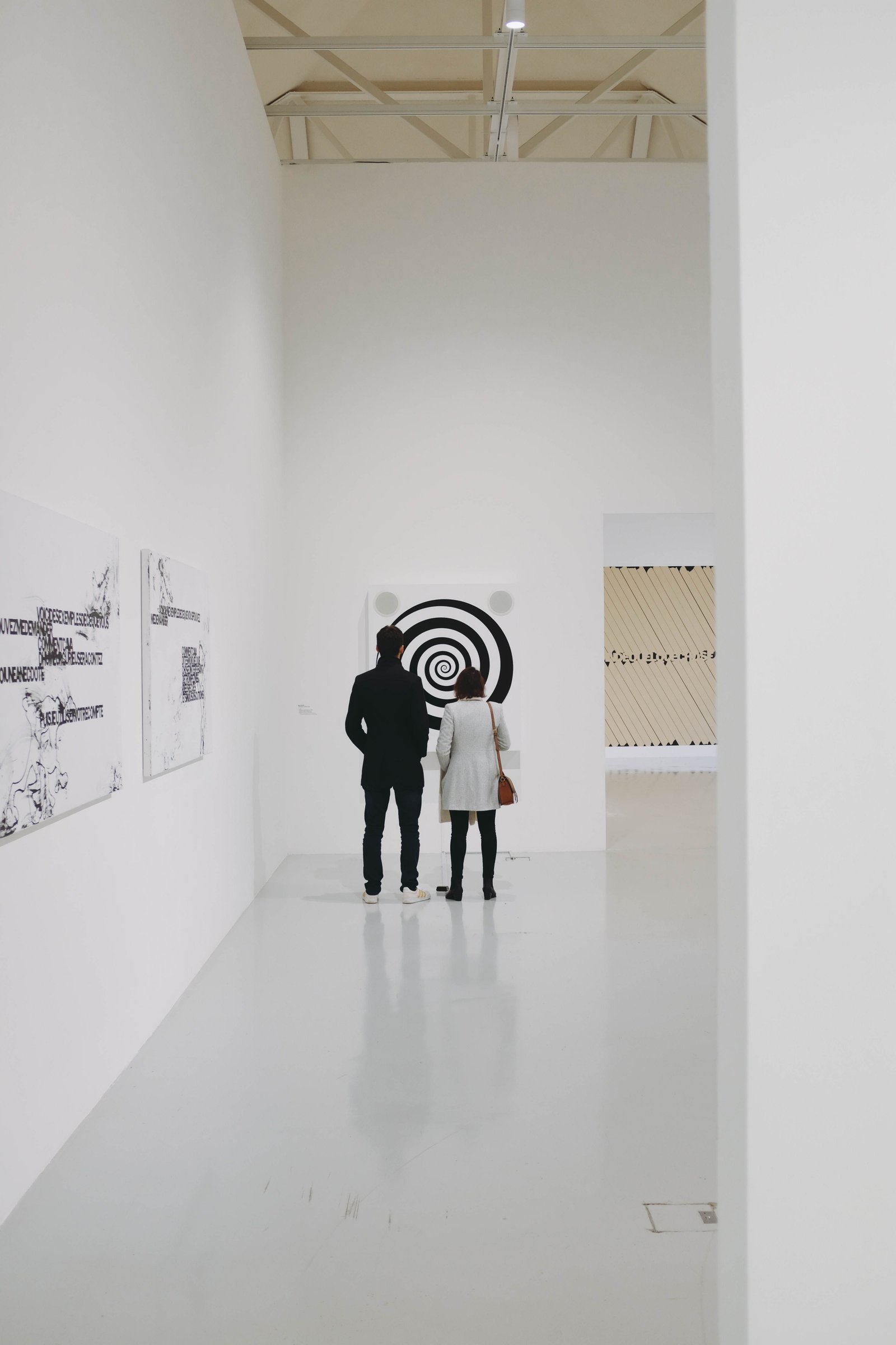 Visiteurs devant une œuvre graphique dans une galerie d'art contemporain