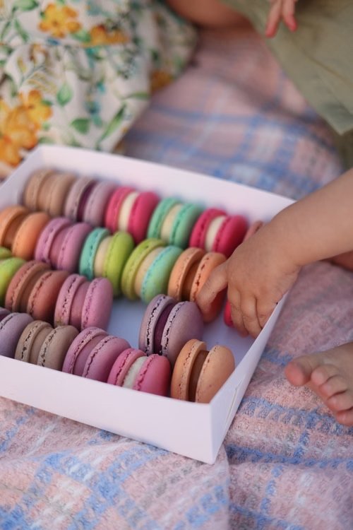 Enfant choisissant des macarons colorés