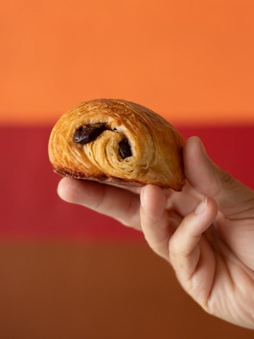 Pain au chocolat tenu à la main