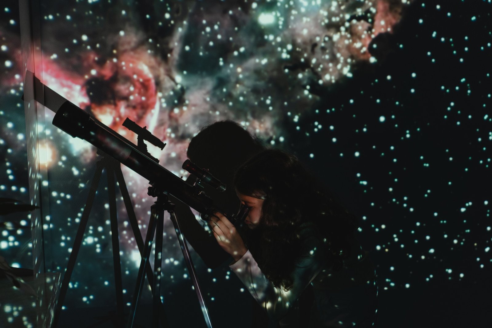 Enfant observant les étoiles au télescope dans un planétarium